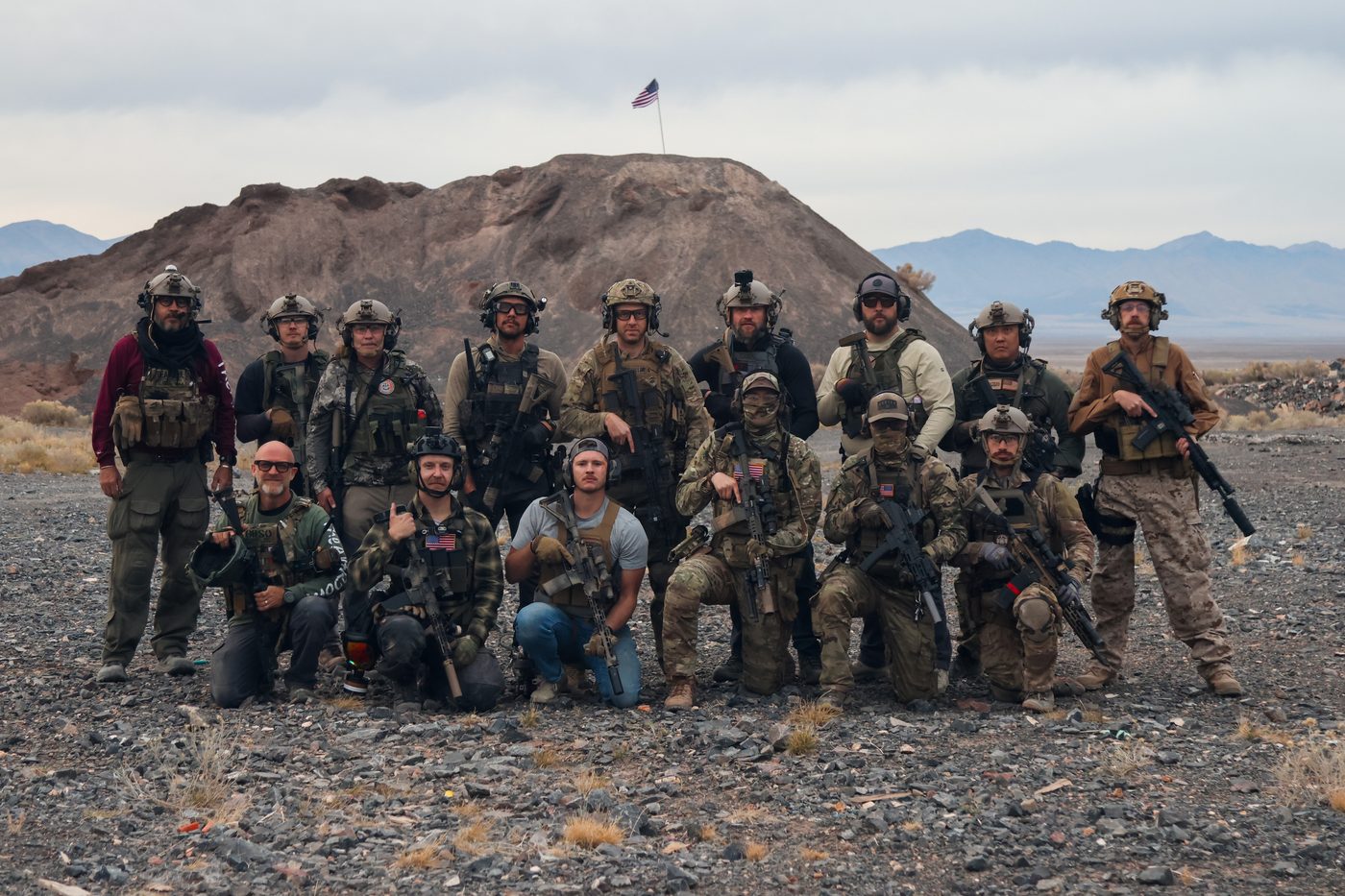 The Art Room trainees posing with rifles on a hillside