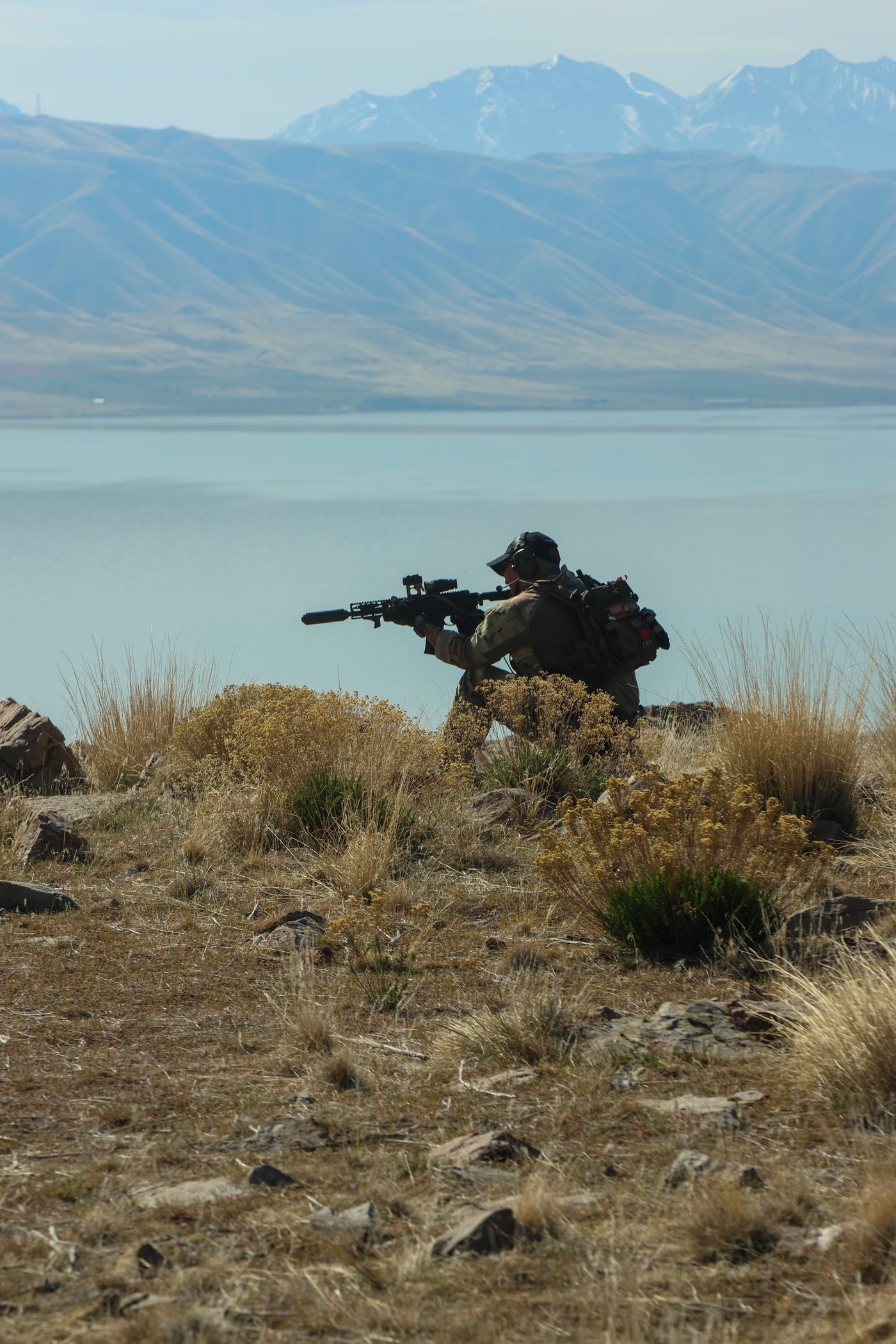 A trainee in position during a course exercise, mountain lake in background