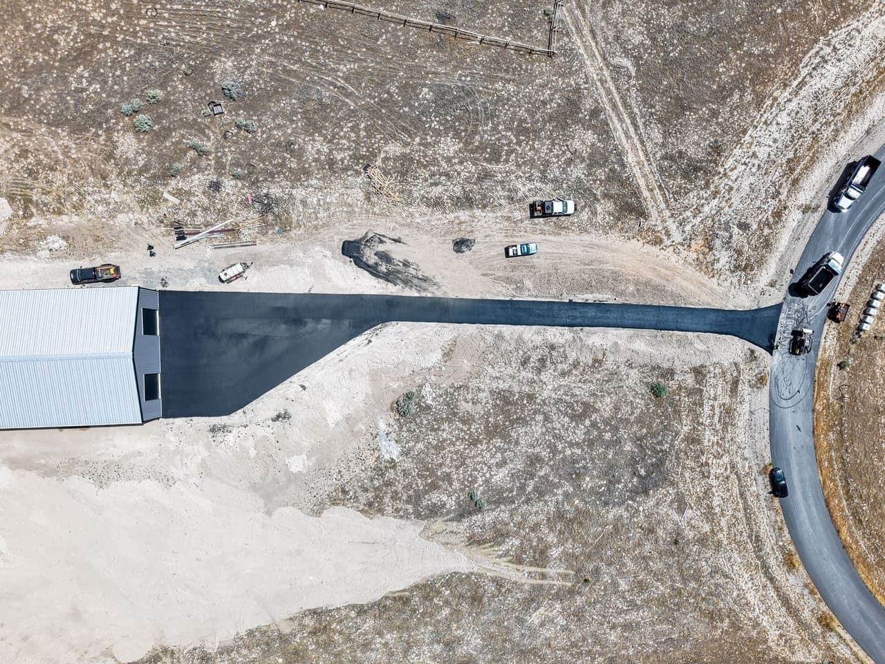 Aerial top-down view of a finished J&C Asphalt driveway