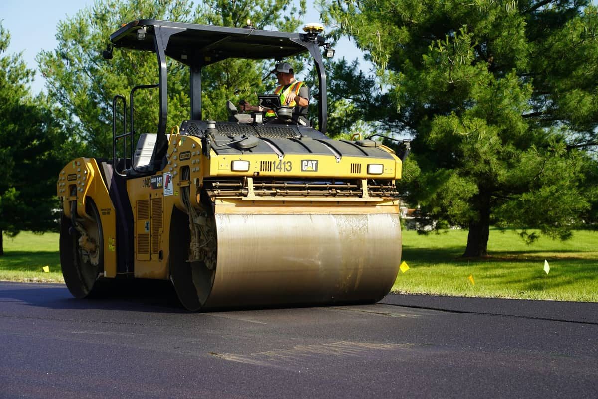 An asphalt roller compacting a fresh driveway