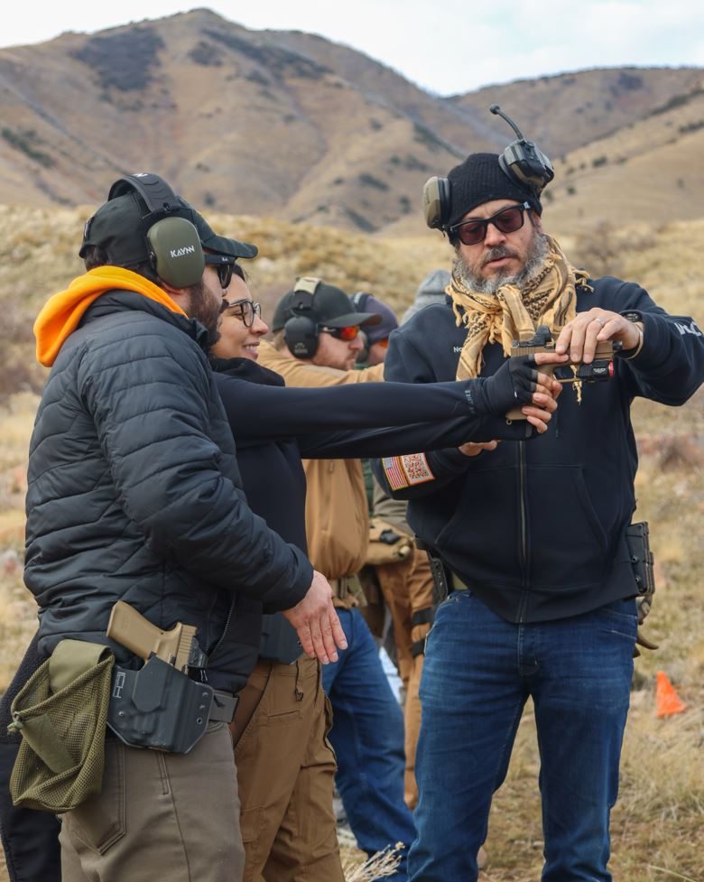 Noah, an instructor, teaching a firearms training course outdoors