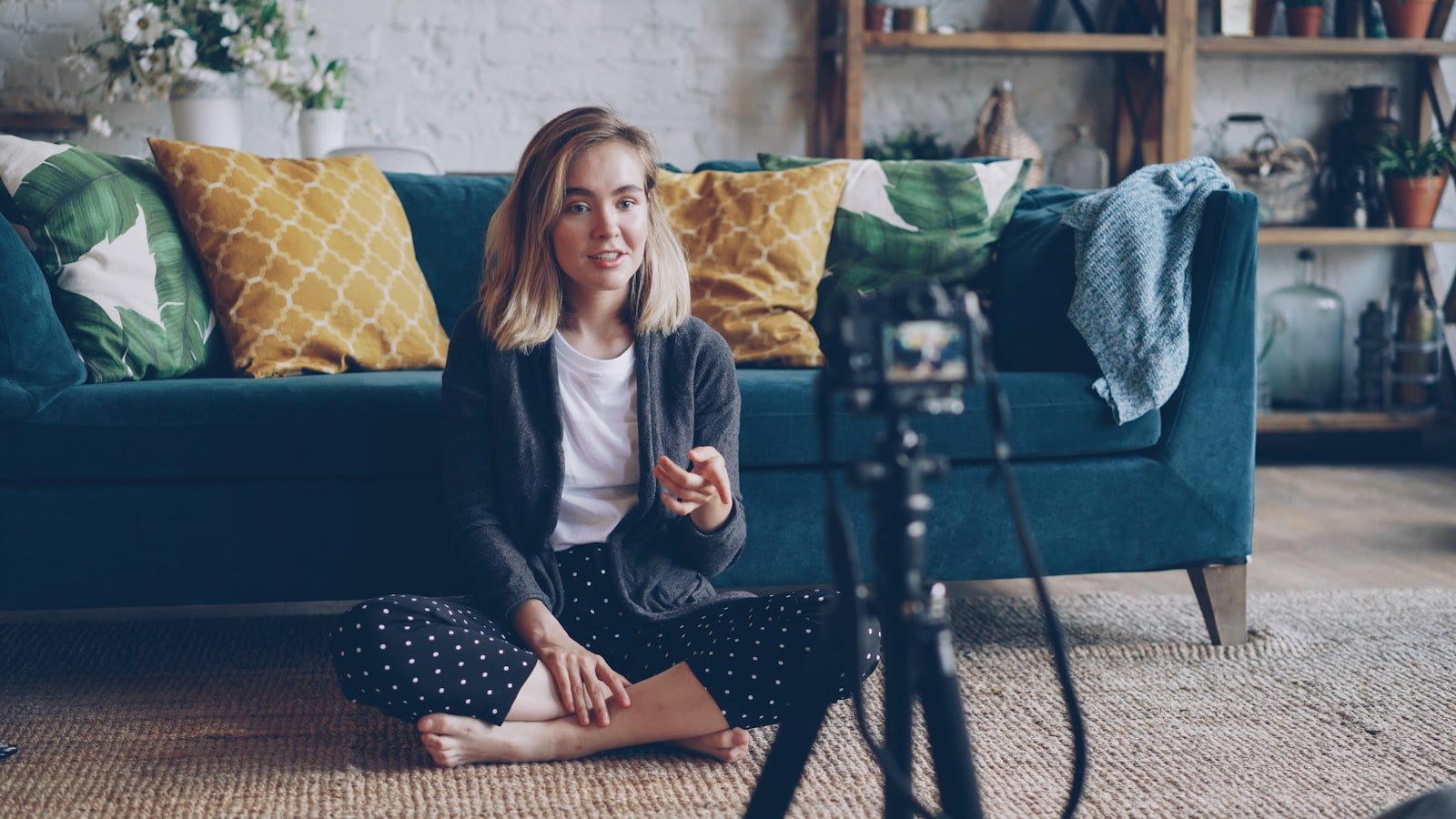 A content creator recording video on a camera and tripod for her audience