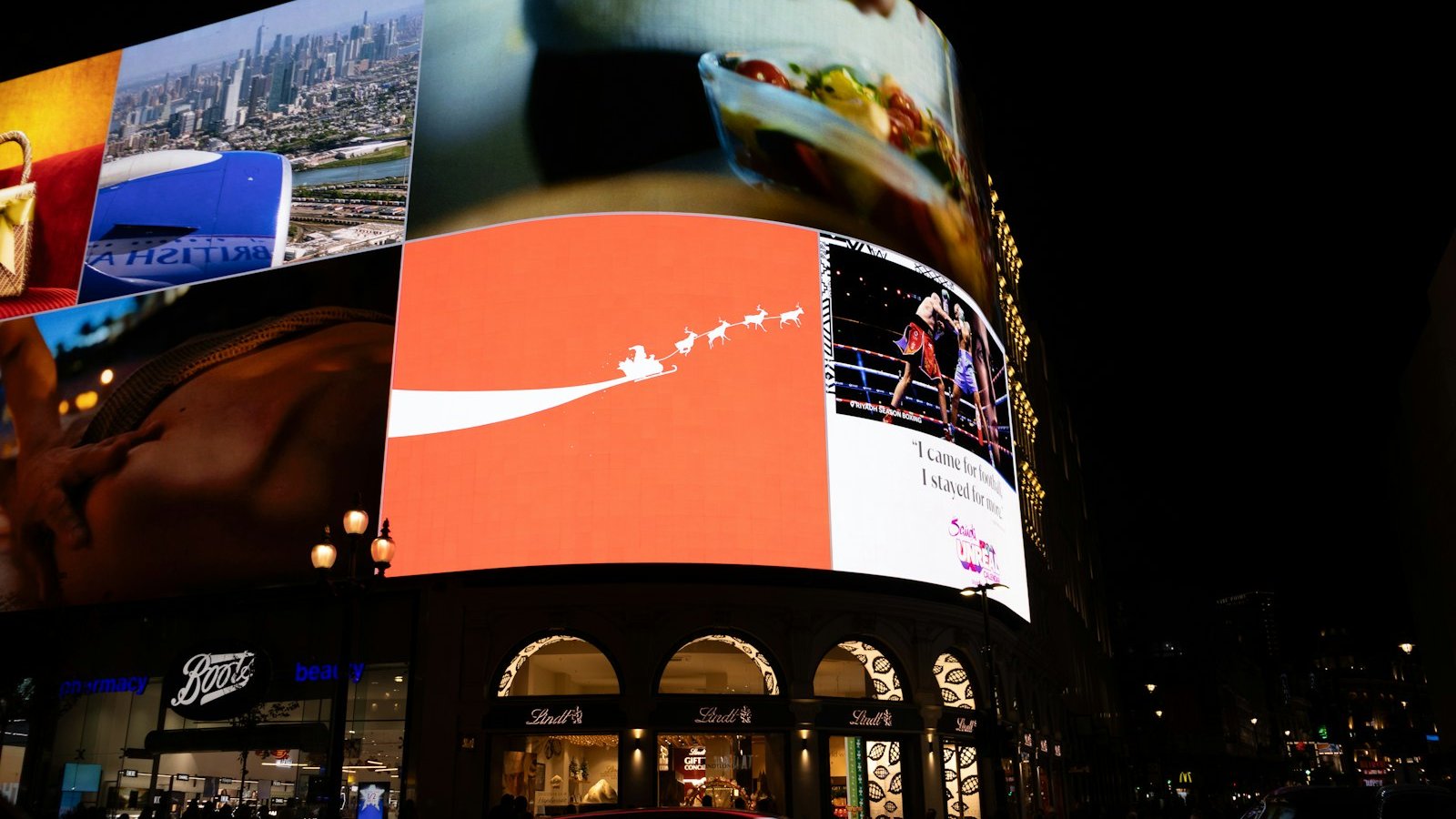 Bright digital billboards illuminating a city street at night